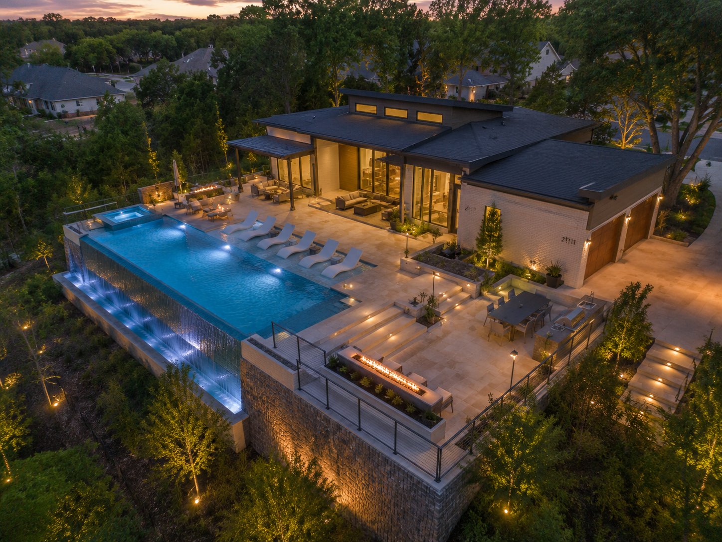 Generated rendering of an infinity-edge pool lit at dusk behind a modern house